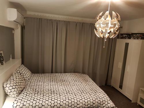 a bedroom with a bed and a chandelier at Marcos Apartments in Reşiţa