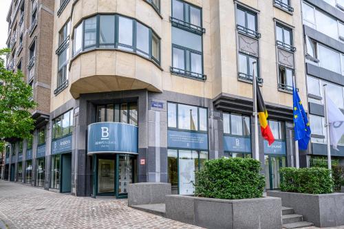a building with two flags in front of it at B-aparthotel Ambiorix in Brussels