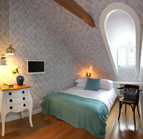 a bedroom with a bed and a table and a tv at Águamel Sintra, Boutique Guest House in Sintra