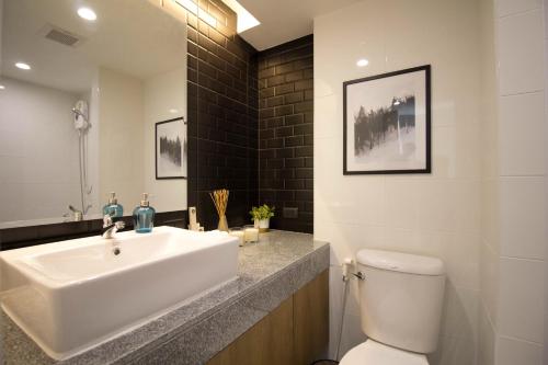 a bathroom with a white sink and a toilet at B Stay Hotel in Bangkok
