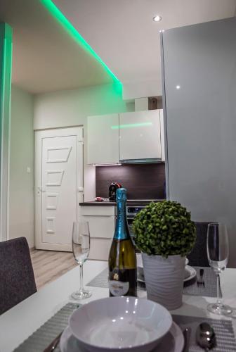 a bottle of wine sitting on a table with wine glasses at Downtown Dream Apartmans in Szeged