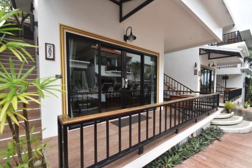 a house with a balcony with glass doors at Simple Life Cliff View Resort in Koh Tao