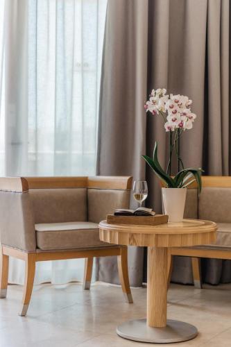 a living room with a table with a vase of flowers at Lindos Imperial Resort & Spa in Kiotari