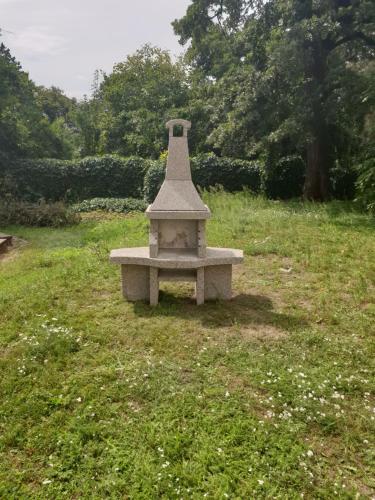 un banco de piedra sentado en un campo de hierba en Koleje Zamecek, en Lednice