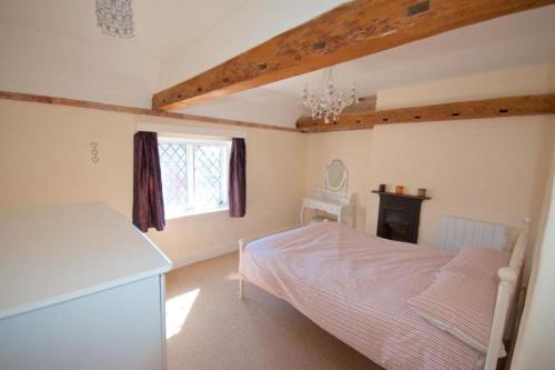 um quarto com uma cama e uma janela em Wish Cottage em Ratton Village