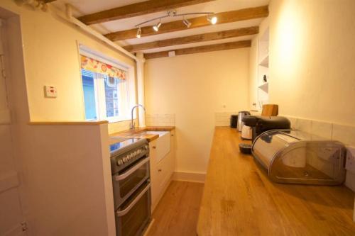 a kitchen with a sink and a stove top oven at Wish Cottage in Ratton Village