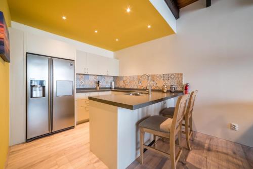 a kitchen with a counter and a refrigerator at Punda City Centre Penthouse in Willemstad