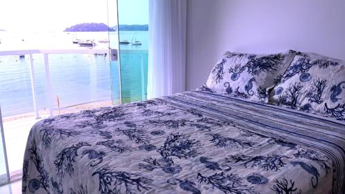 a bedroom with a blue and white bed with a window at Apto Praia Grande - Angra dos Reis in Angra dos Reis