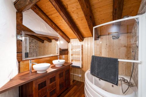 ein Badezimmer mit 2 Waschbecken und einer Badewanne in der Unterkunft Les Balcons du Molliebon in Séez