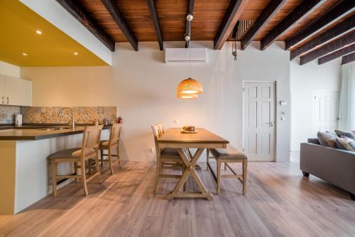 a kitchen and dining room with a wooden table and chairs at Punda City Centre Penthouse in Willemstad