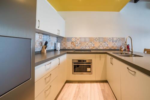 a kitchen with white cabinets and a sink at Punda City Centre Penthouse in Willemstad
