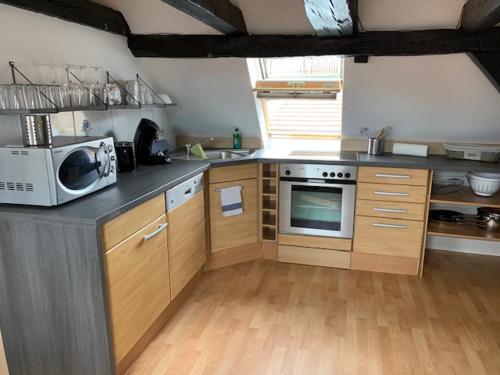 a kitchen with a microwave and a stove in it at Gästehaus Windheim (Karlsruher Denkmal) in Karlsruhe