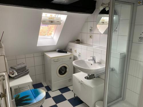 a bathroom with a sink and a washing machine at Gästehaus Windheim (Karlsruher Denkmal) in Karlsruhe