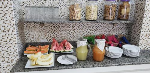 a table with plates of food and drinks on a counter at Pousada Azevedo in Livramento de Nossa Senhora