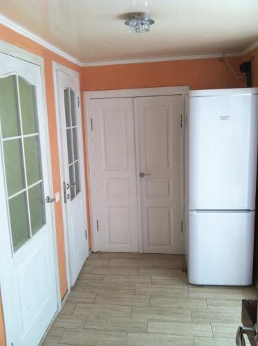 a kitchen with a white refrigerator and orange walls at House with flowers in Zatoka