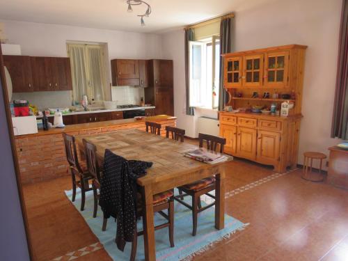 eine Küche mit einem Holztisch und einigen Stühlen in der Unterkunft Vecchia Saimpa in Anfo