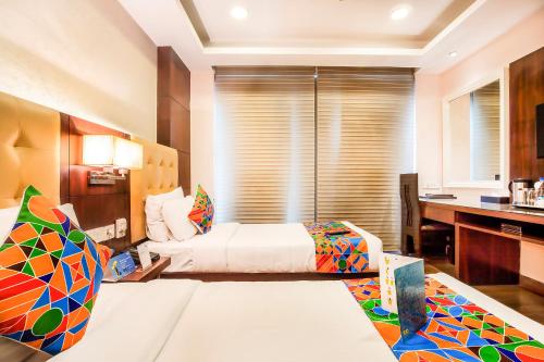a hotel room with a bed and a desk at Jasmine Boutique Hotel Jasola in New Delhi