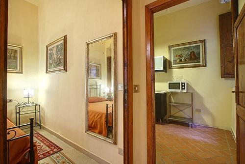 einen Flur mit einem Zimmer mit einem Bett und einem Spiegel in der Unterkunft Nerii 3 in Florenz