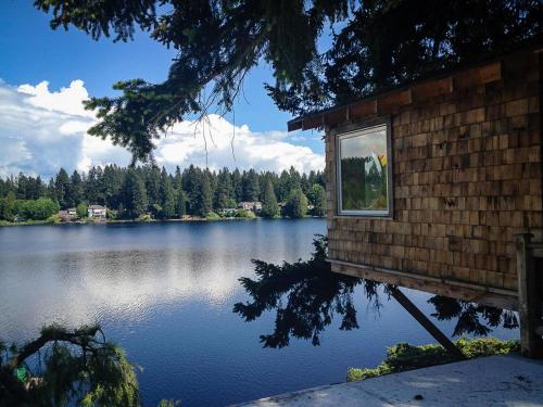 a building with a window on the side of a lake at Cottage Lake Bed and Breakfast in Woodinville