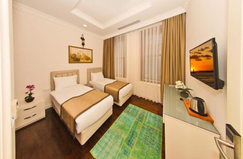 een hotelkamer met 2 bedden en een bureau bij Nusretbey Hotel in Istanbul