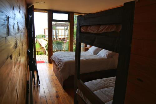 a bedroom with two bunk beds and a doorway at Ruka Antu Ecolodge in Cobquecura