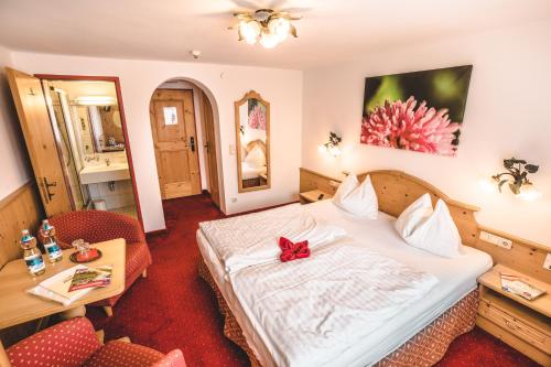 a hotel room with a bed with a red bow on it at Hotel Metzgerwirt in Kirchberg in Tirol
