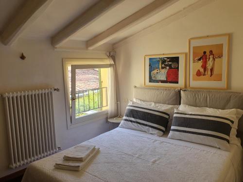 a bedroom with a bed with two pillows and a window at B&B Griffoni 7 in Bologna