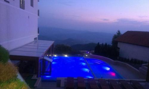 a swimming pool at night with blue lights at Kopaonik Milmari apartman L33 in Kopaonik