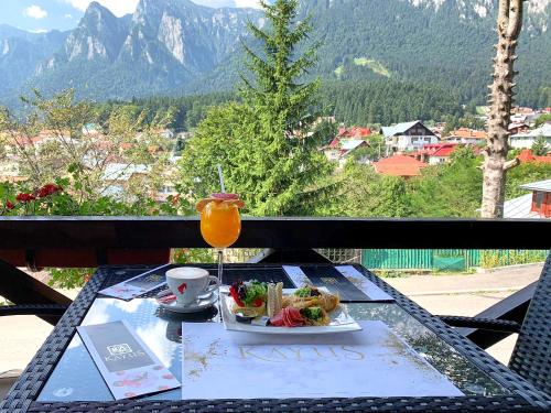 a table with a plate of food and a drink at Kayus in Buşteni