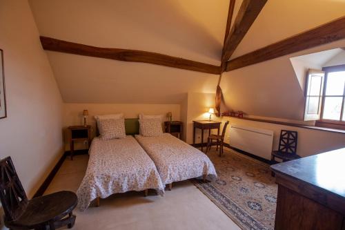 a bedroom with a bed and a table and a window at La Buffonnerie in Moutiers-Saint-Jean