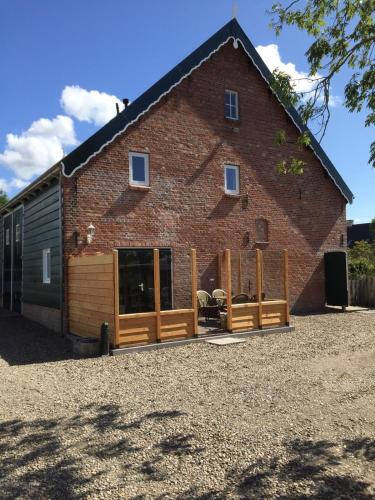 a large brick building with wooden gates in front of it at In de Zeeuwse Schuur in Biggekerke