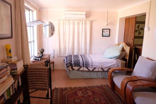 Habitación pequeña con cama y ventana en Neels Cottage, en Clanwilliam