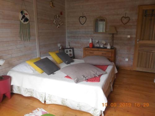 ein Schlafzimmer mit einem weißen Bett und einer Holzwand in der Unterkunft La maison bleue in LʼIsle-sur-la-Sorgue