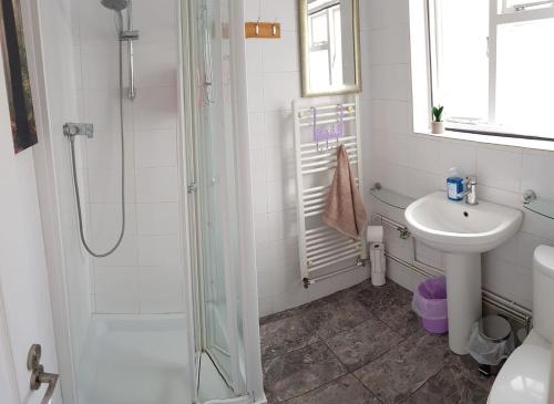 uma casa de banho com um chuveiro e um lavatório. em Charming grade 2 listed house em Canterbury