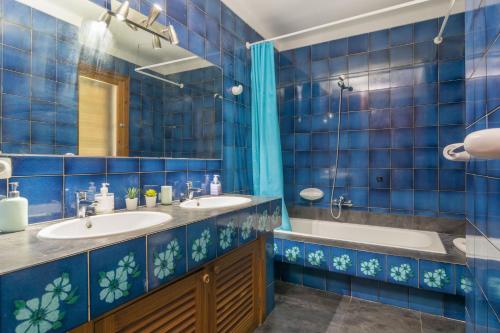 a blue tiled bathroom with two sinks and a tub at S'Olivaret -Alcudia- in Port d'Alcudia