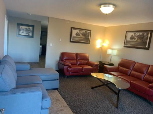 a living room with couches and chairs and a table at Super 8 by Wyndham Fort McMurray in Fort McMurray