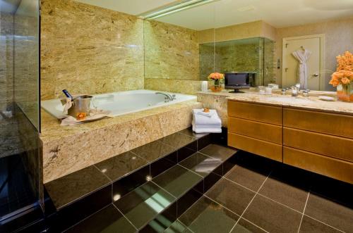 a bathroom with a sink and a bath tub at Hotel De Anza, a Destination by Hyatt Hotel in San Jose