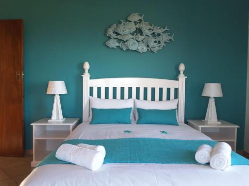a bedroom with a white bed with blue walls at Lewensdroom Self Catering in Tergniet