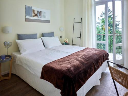 una camera da letto con un grande letto bianco e una finestra di Albergo Garnì Villa Moretti a Riva del Garda