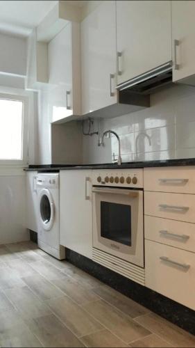 a kitchen with a stove and a washing machine at San Andrés, 93 Apartamento in A Coruña