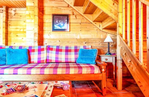 a couch sitting in a room in a cabin at Résidence Néméa Les Chalets du Bois de Champelle in Morillon