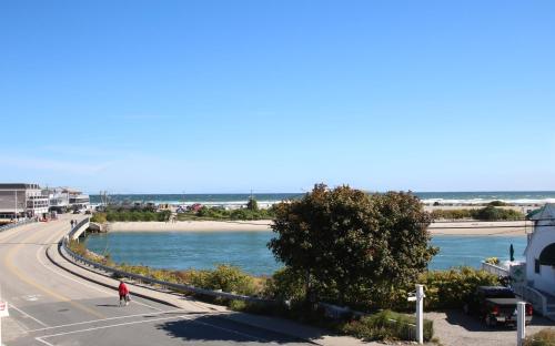 a person riding a bike on a road next to a beach at Aspinquid Resort in Ogunquit