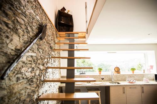 a staircase in a kitchen with a stone wall at ESPIGUEIRO DA CASADA VILLA RURAL - FOZ DO DOURO by LW in Foz do Sousa
