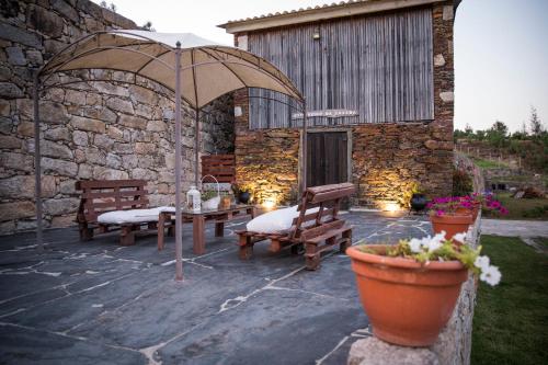 a patio with two benches and an umbrella at ESPIGUEIRO DA CASADA VILLA RURAL - FOZ DO DOURO by LW in Foz do Sousa