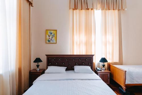 1 dormitorio con 2 camas y ventana grande en Lion B&B, en Samarkand