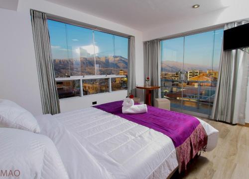 sypialnia z białym łóżkiem i dużym oknem w obiekcie Latinos House Cusco w Cuzco
