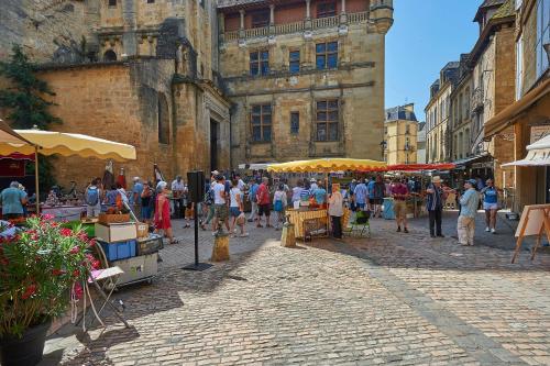 a group of people walking around a market in a street at Village de Montmarsis in Gourdon-en-quercy