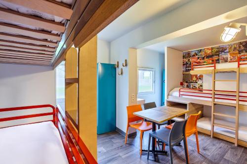 サン・ドニにあるhotelF1 Paris Saint Denis Universitéのベッド、テーブル、椅子が備わる客室です。
