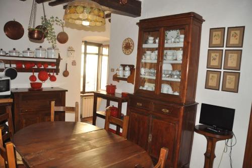 a dining room with a wooden table and a cabinet at Borgo la Ruga - Tuscany Home in Chianni