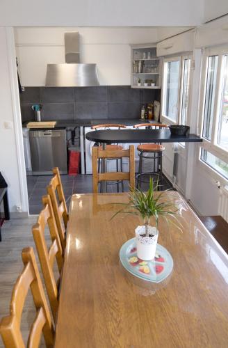 une cuisine avec une table en bois et une plante en pot. dans l'établissement BedinReims 